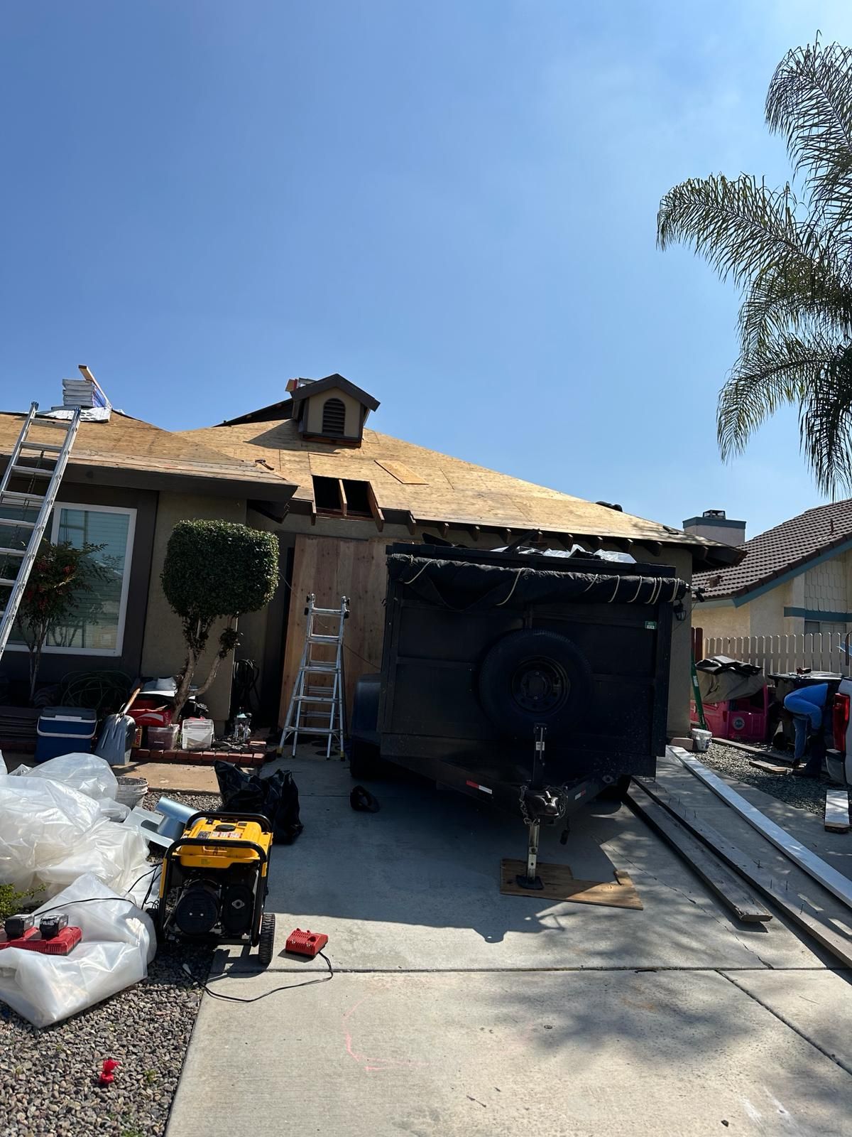 A house with a trailer parked in front of it is being remodeled.