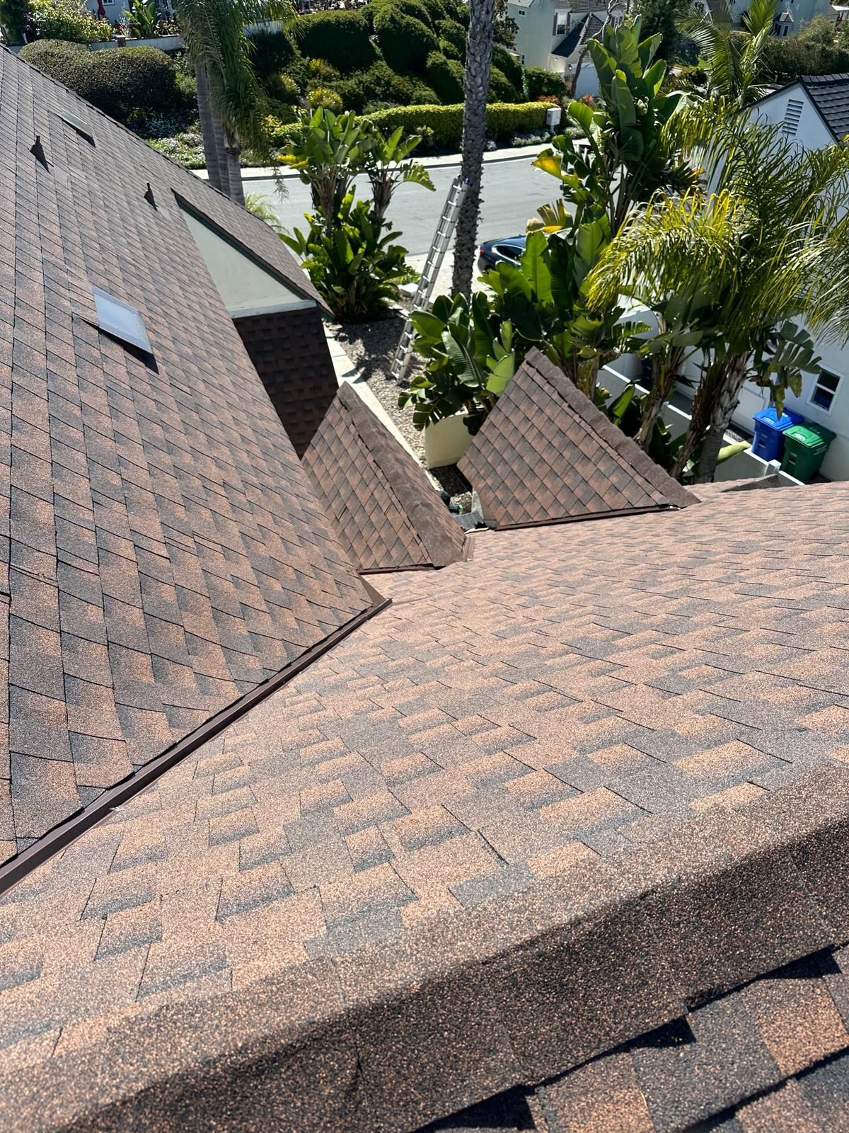 A roof with a lot of shingles and a skylight on it