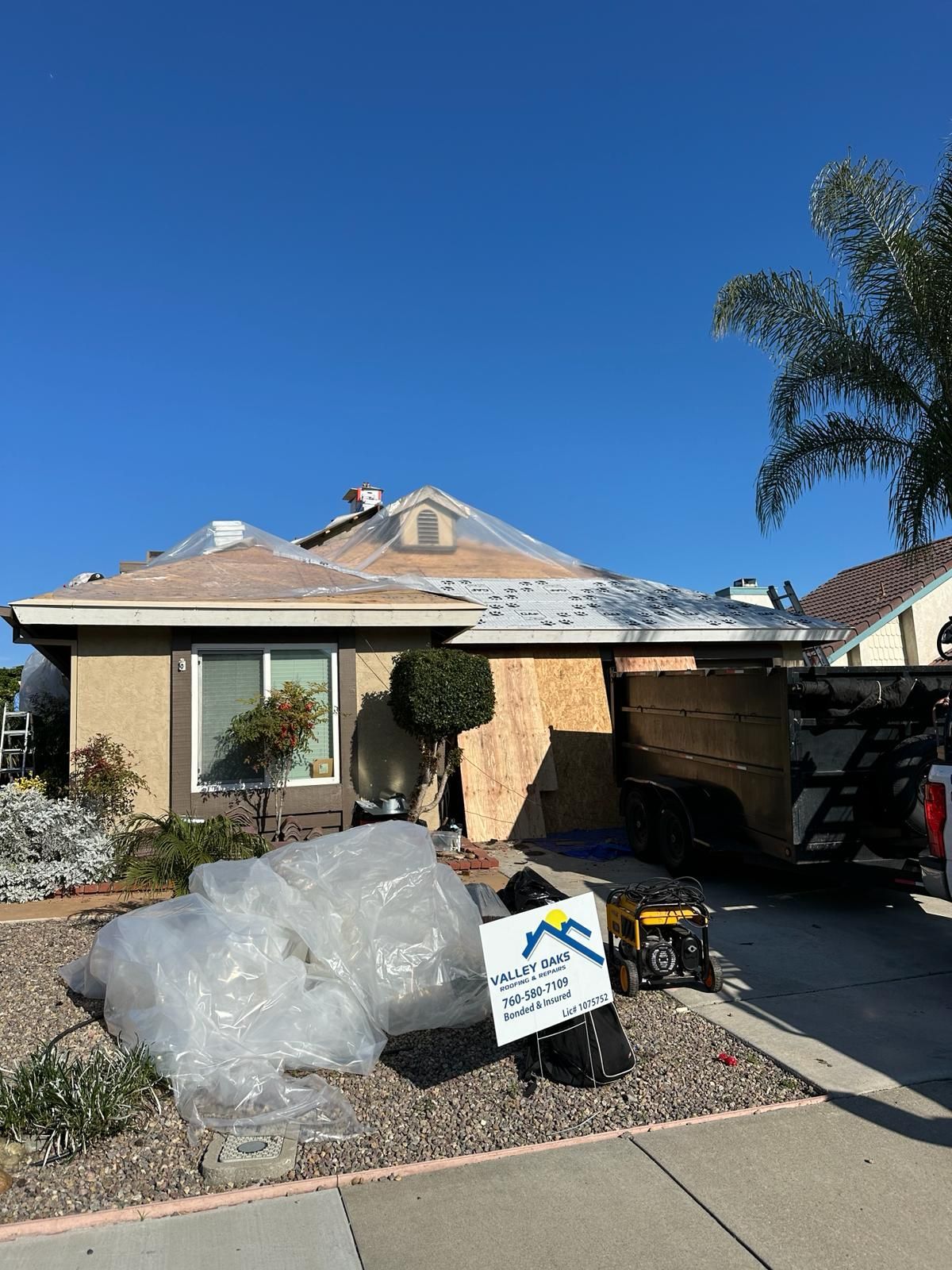 A house is being remodeled with a sign in front of it.
