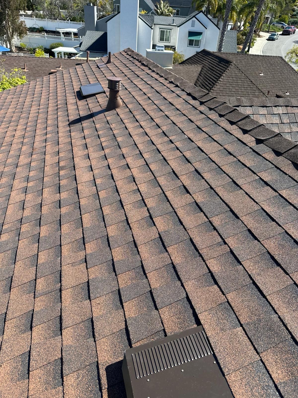 A close up of a roof with shingles and a chimney.