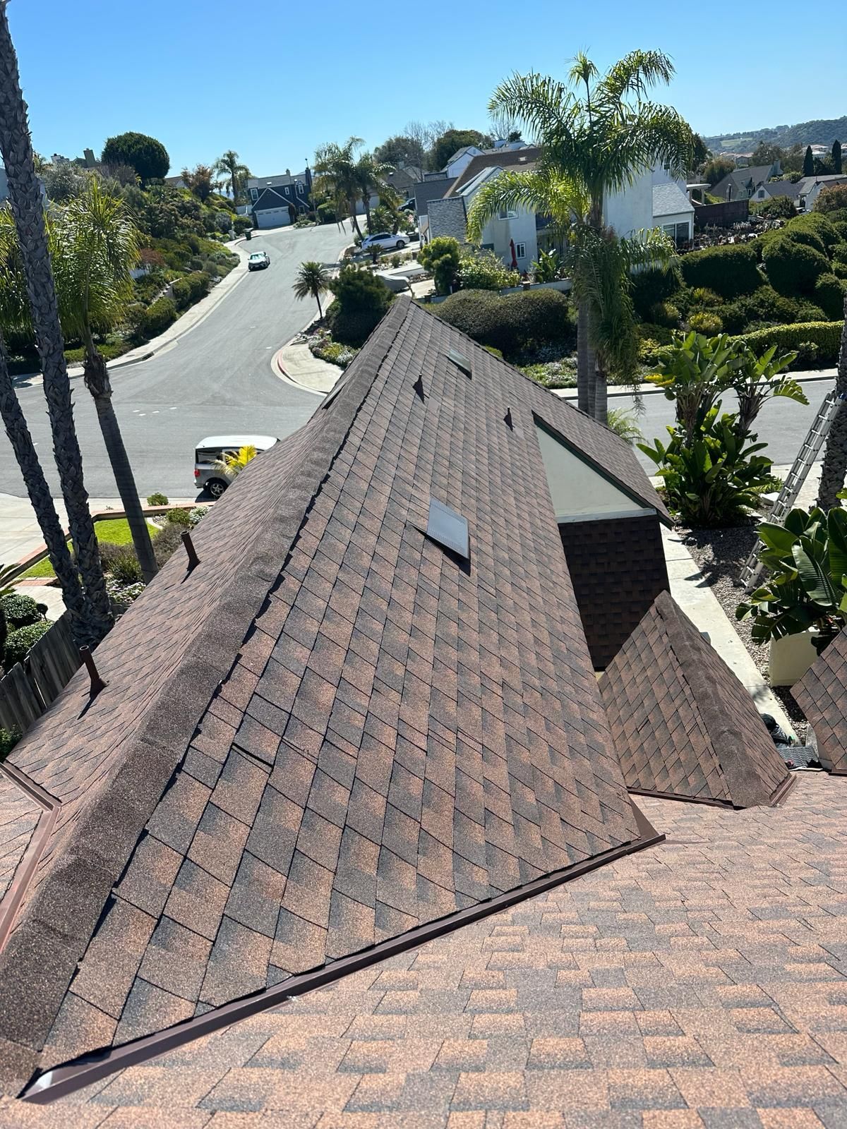 A roof with a skylight on it in a residential area.