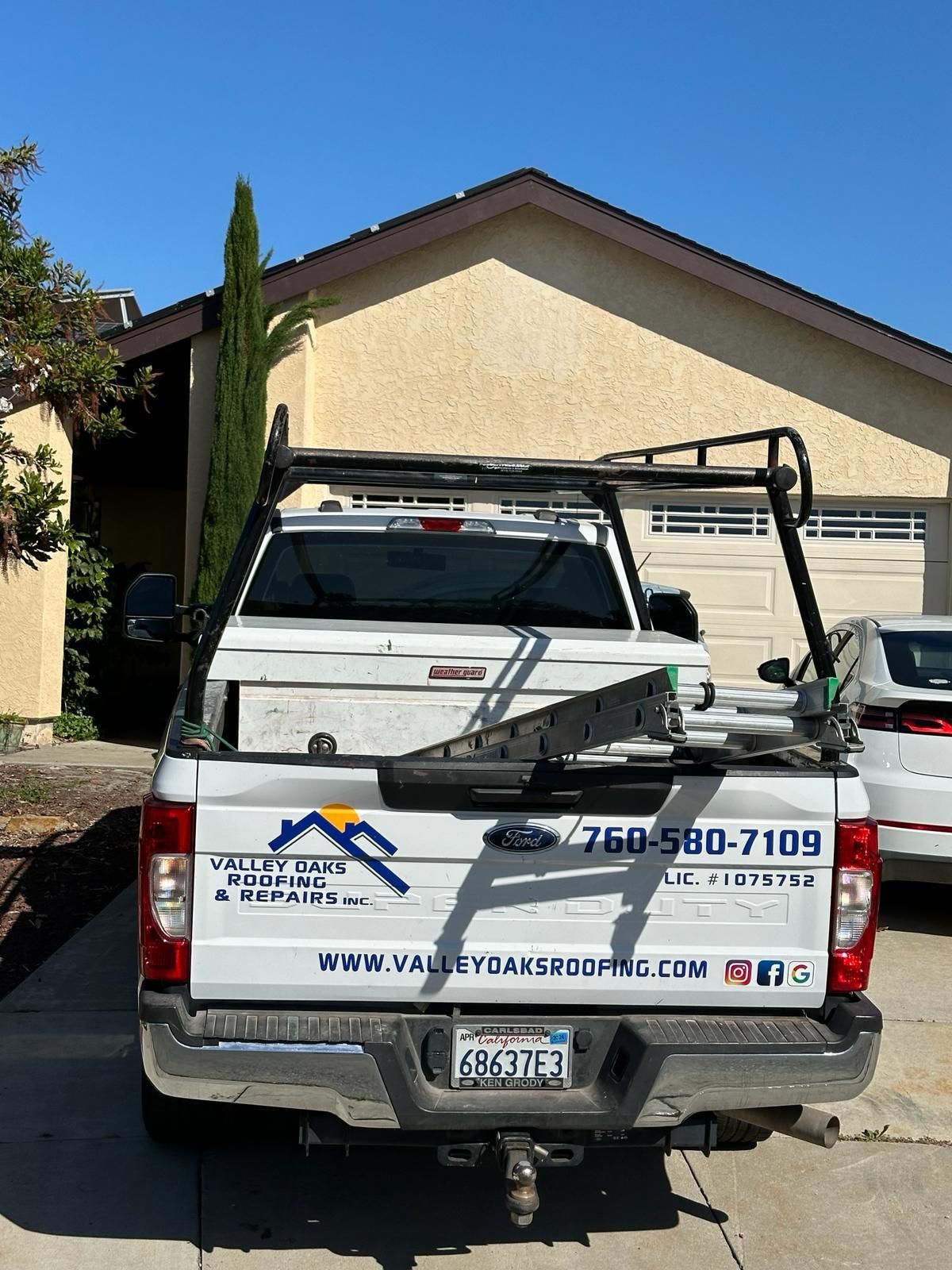 A white truck is parked in front of a house.