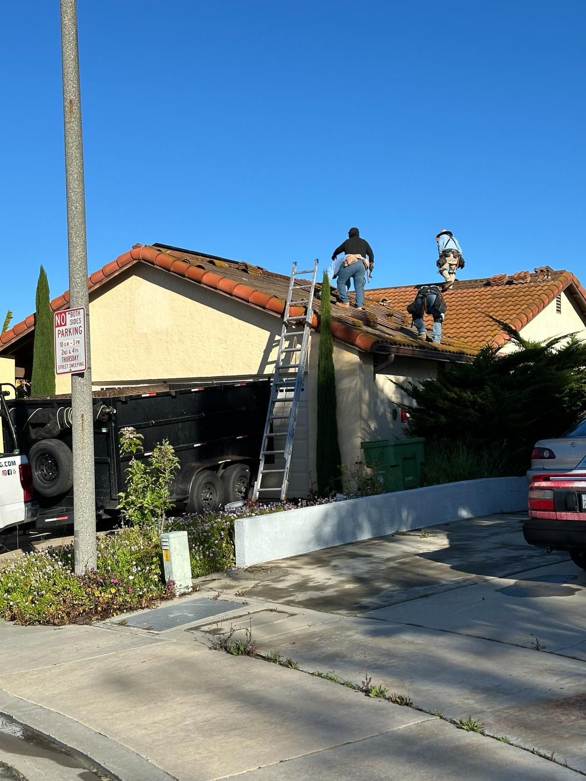 Two men are working on the roof of a house.