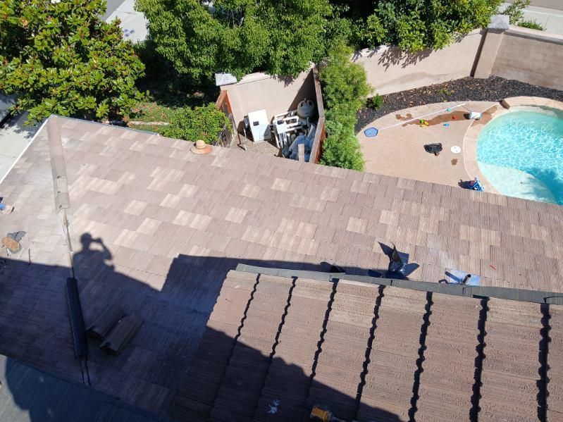 An aerial view of a roof with a pool in the background