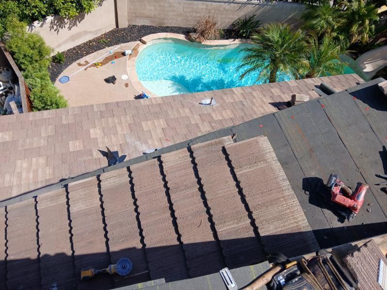 An aerial view of a roof with a pool in the background