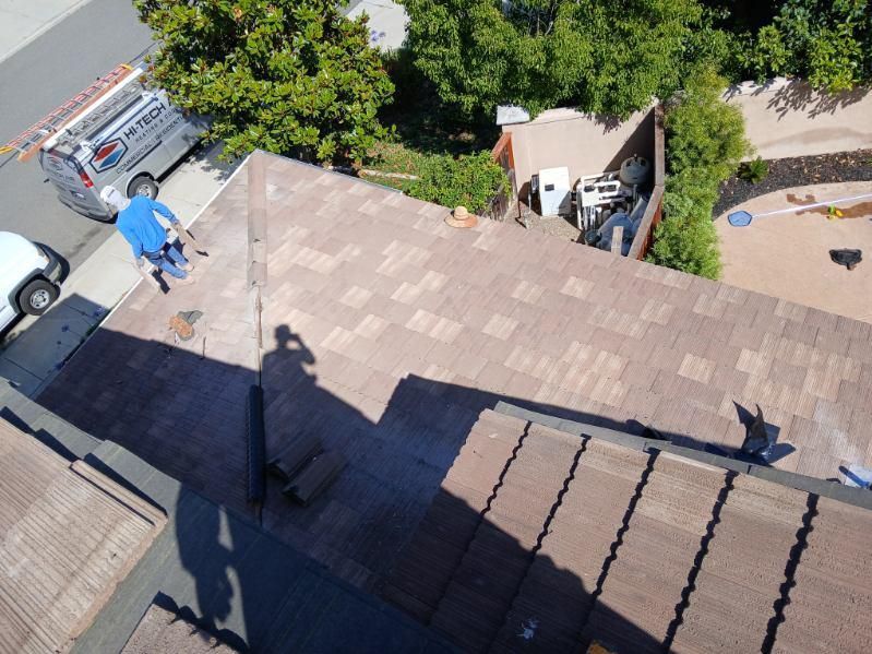 Two men are working on the roof of a house