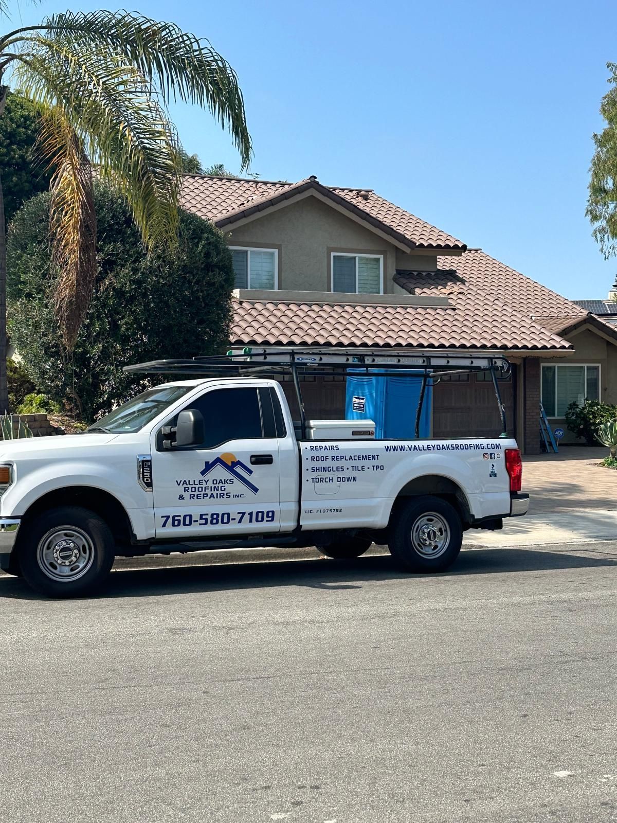A white truck is parked in front of a house.