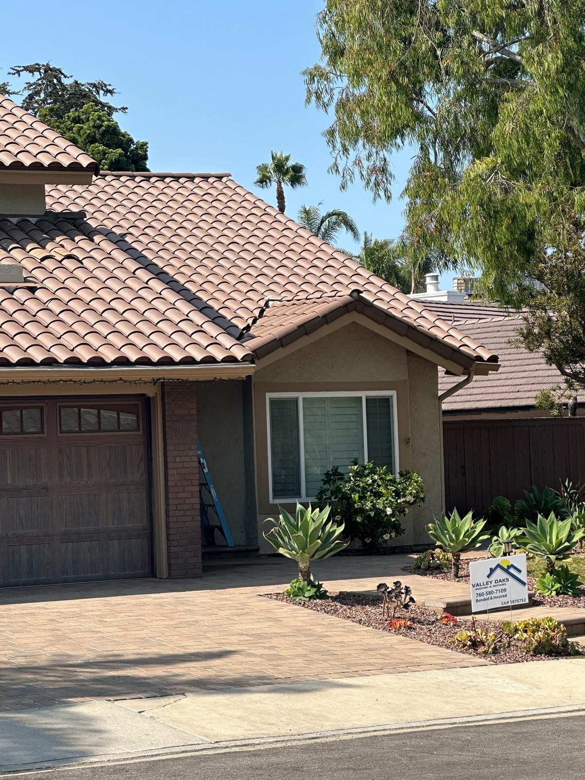 A house with a tiled roof and a sign in front of it