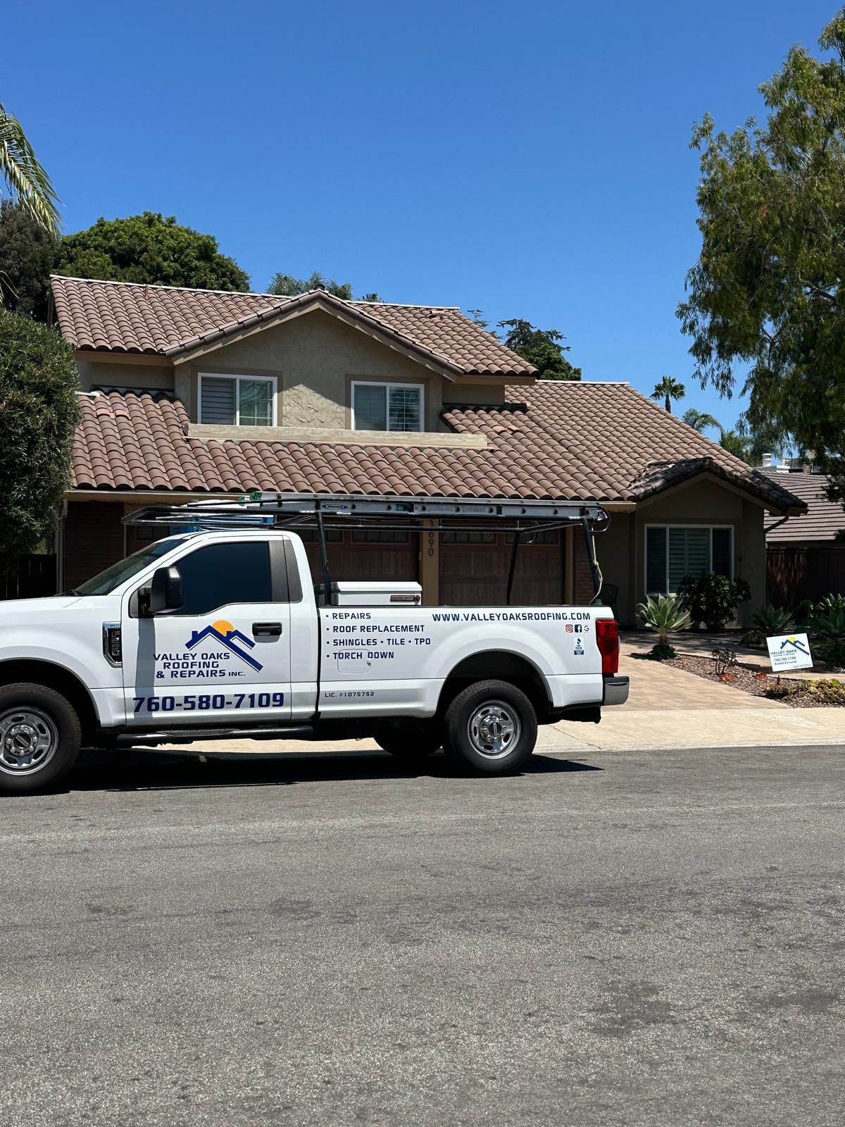 A white truck is parked in front of a house.