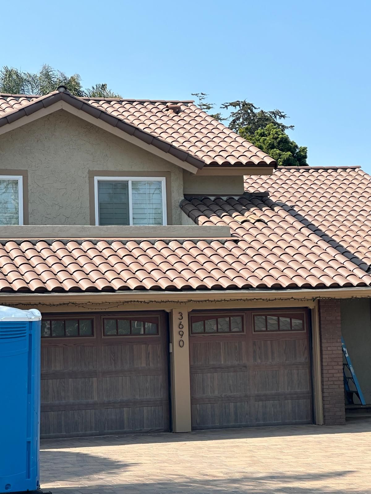A house with a blue portable toilet in front of it