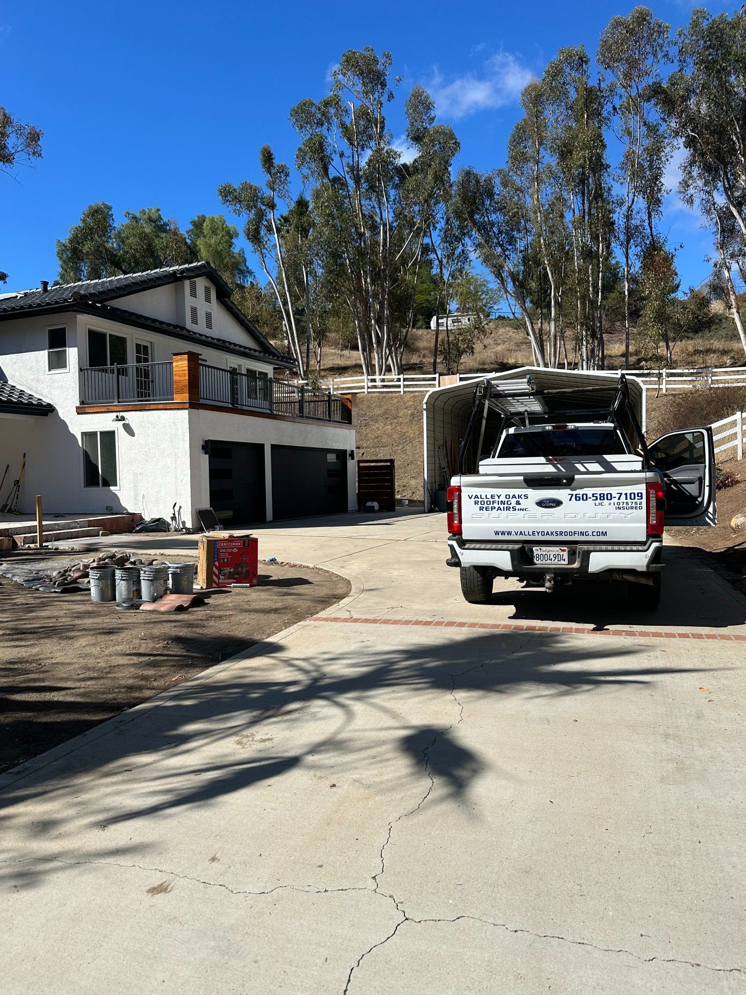 White truck parked near a stucco house with a garage. Sunny day.