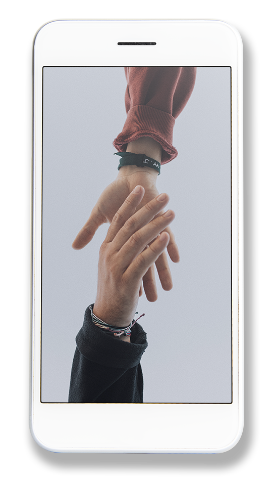 En person holder en anden persons hånd på en mobiltelefon.