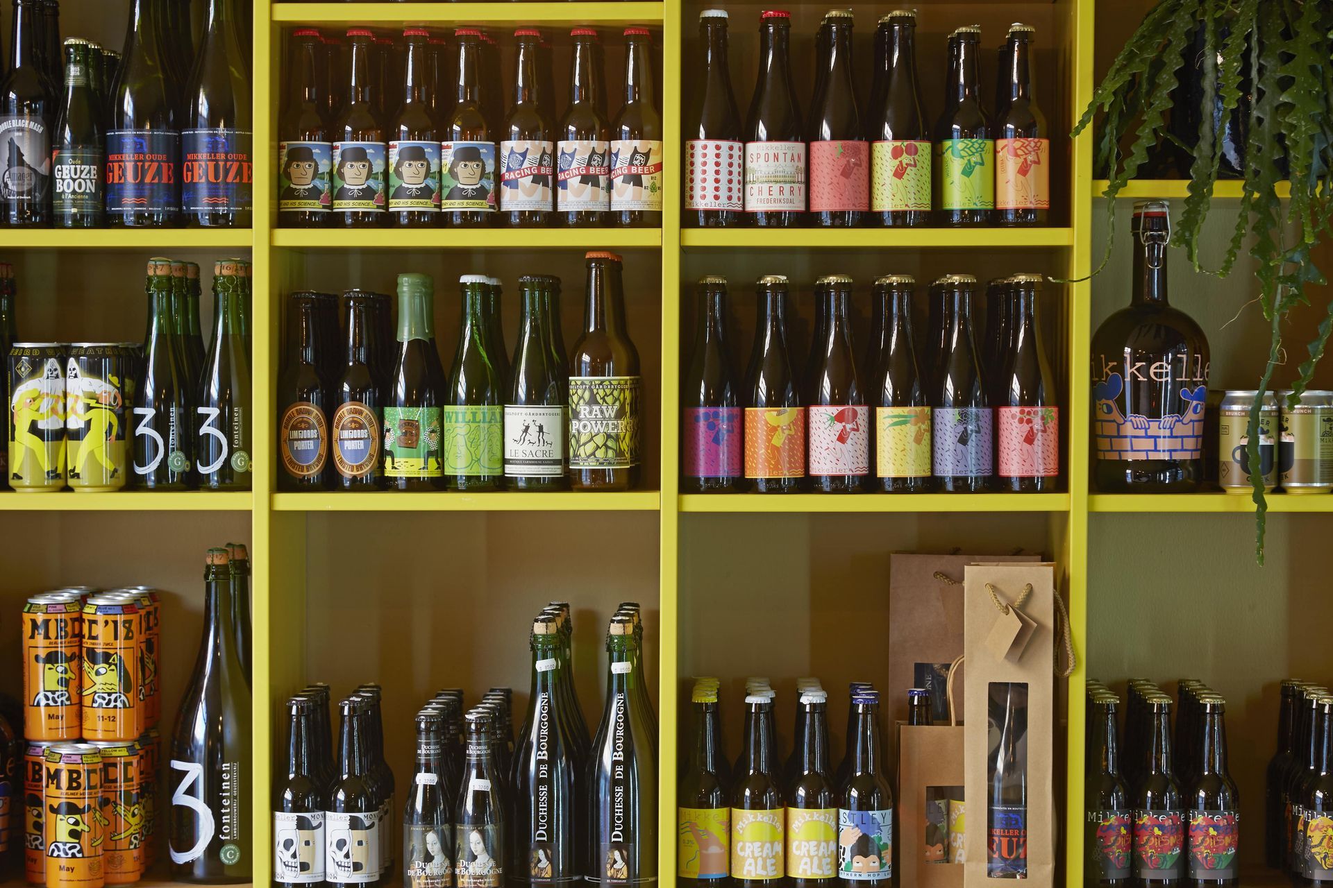 En hylde fyldt med flasker og dåser med øl