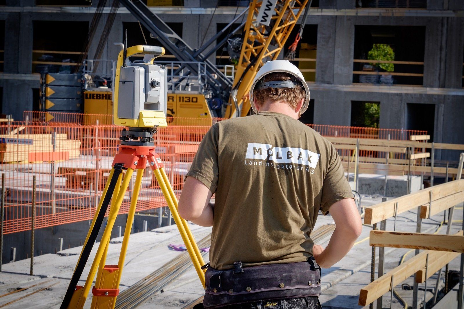 A man is standing on a construction site looking at a camera.