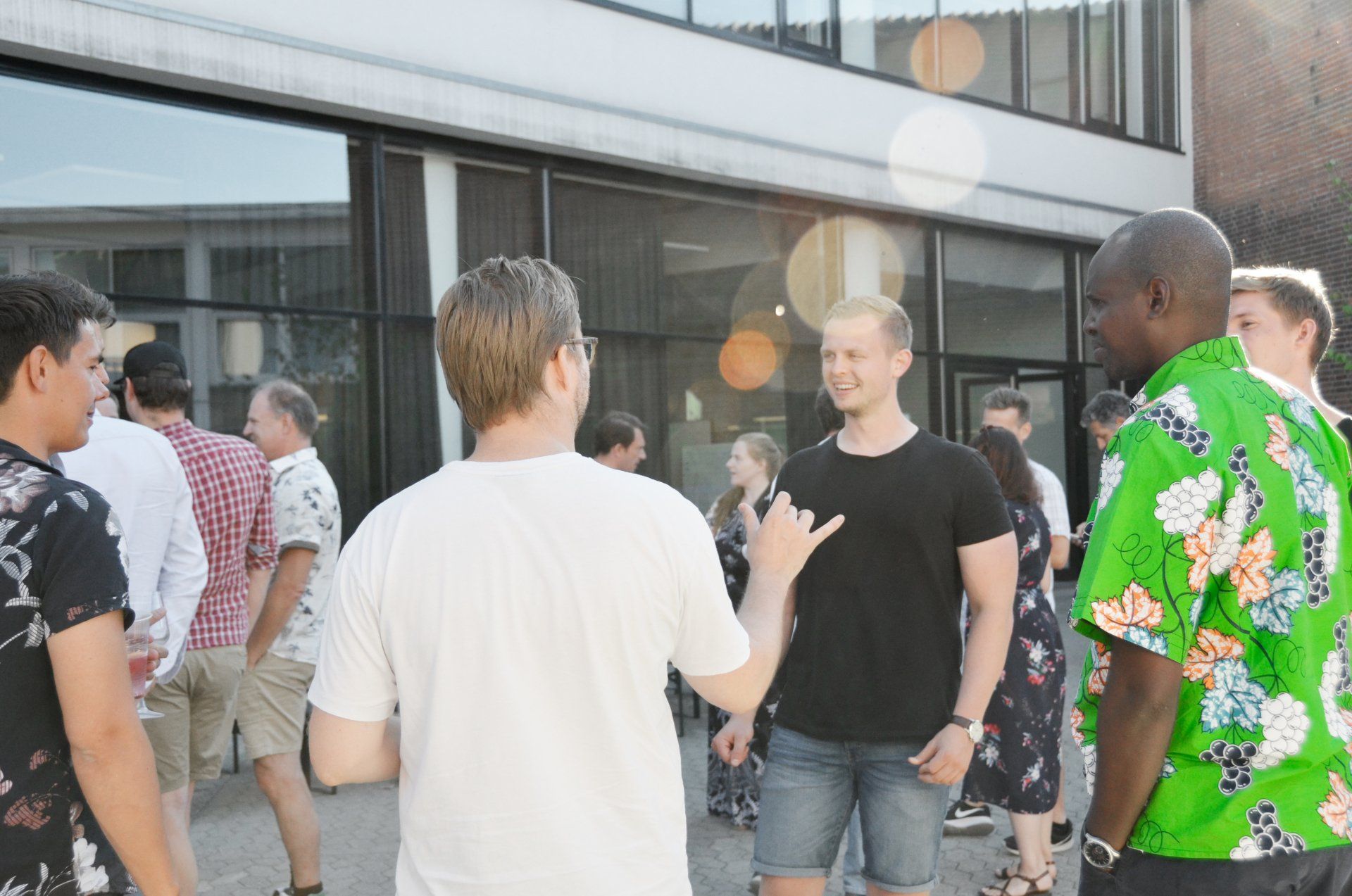 A group of people are standing outside of a building talking to each other.