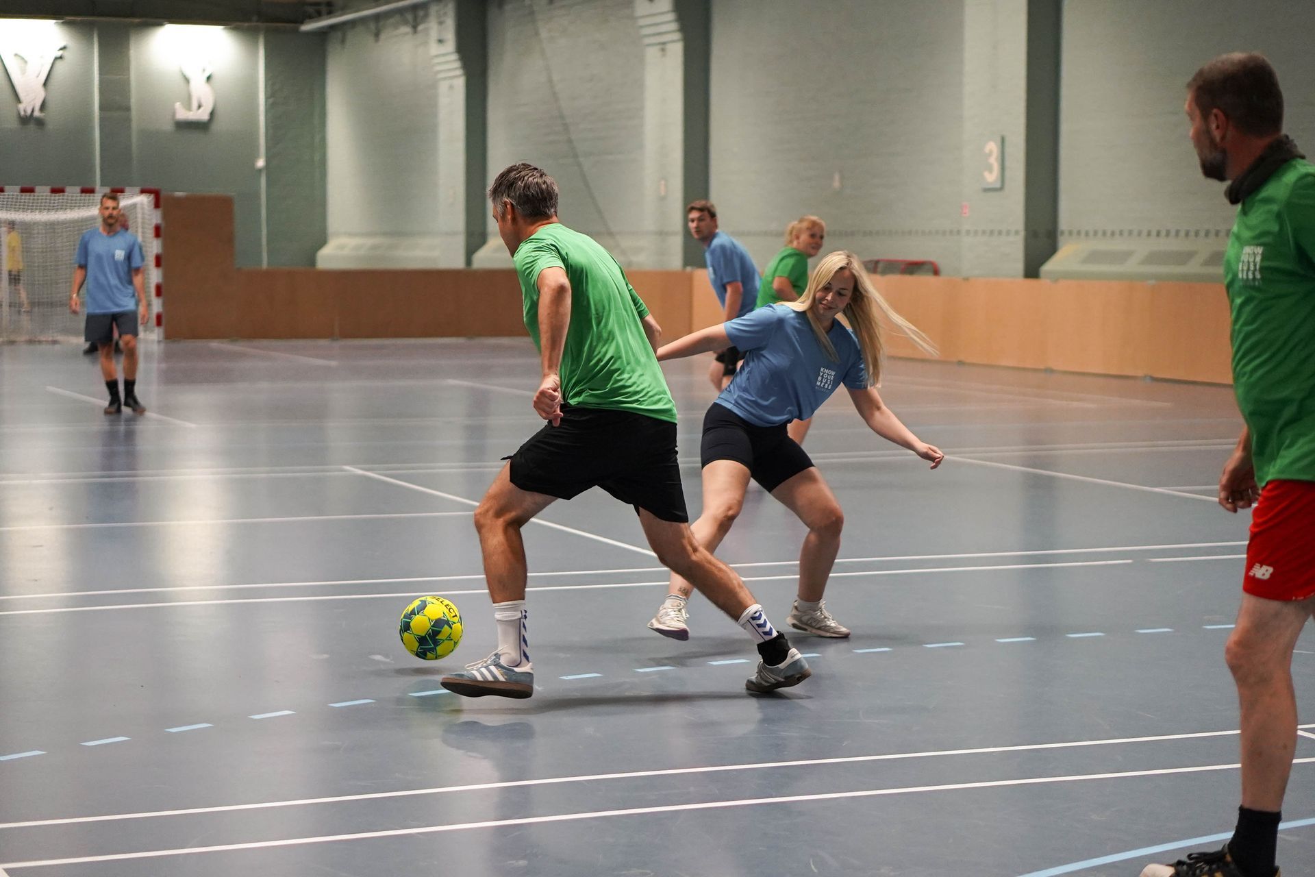 En gruppe mennesker spiller fodbold i et fitnesscenter.