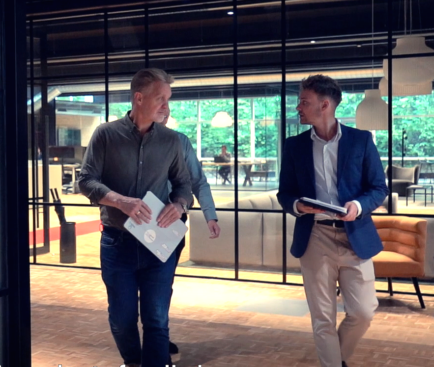 To glas øl på et bord med tønder i baggrunden