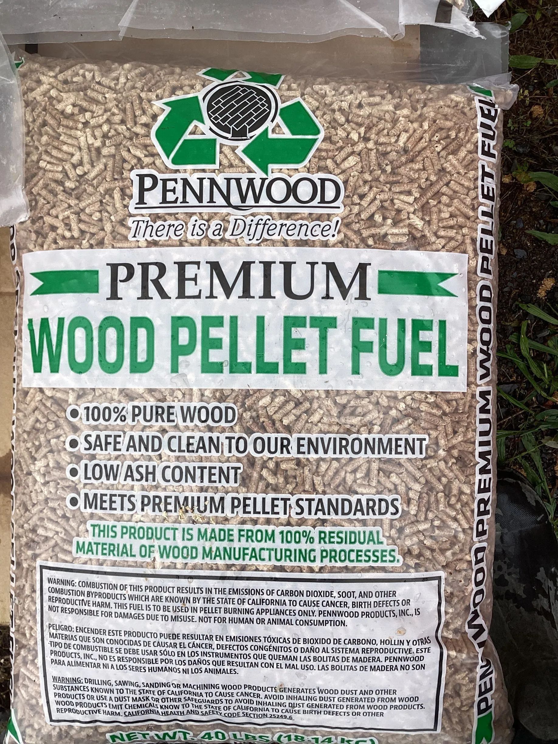 A bag of Pennwood Premium Wood Pellet Fuel with green text on a white background, containing 100% pure wood pellets.