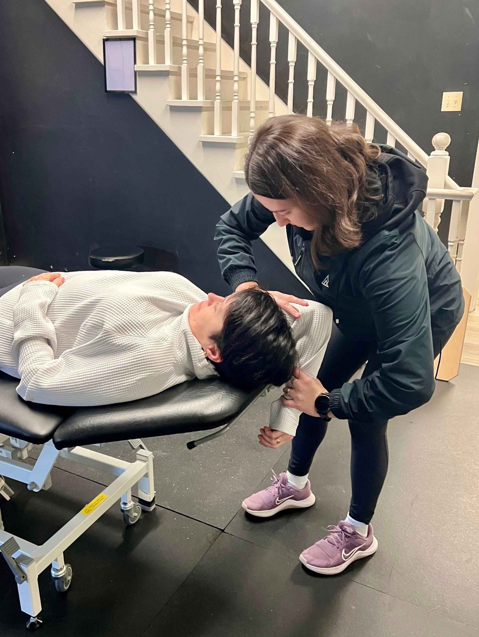 Propel Active Health & Lifestyle Kinesiologist stretching a patient's shoulder during an Assisted Stretching Session in Burlington