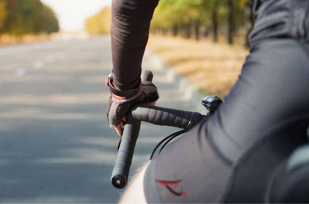 Image of a cyclist holding on to the handlebars. It is used to demonstrate the pressures on the hand and wrist cyclists have to endure.