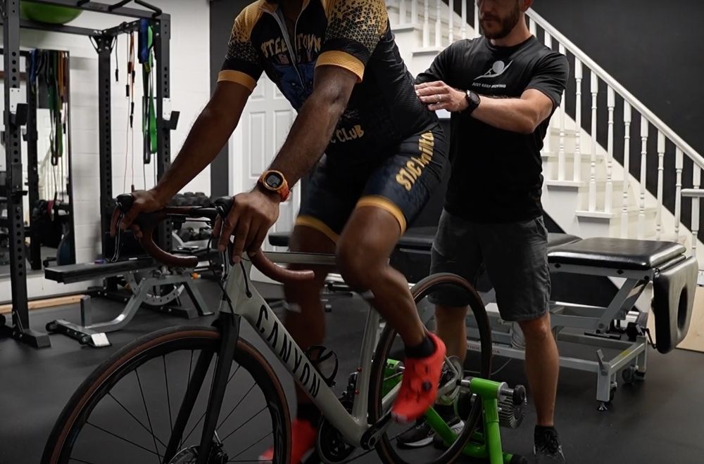 Image of Dr. Peter Lejkowski examining the low back in a cyclist during a bike fit