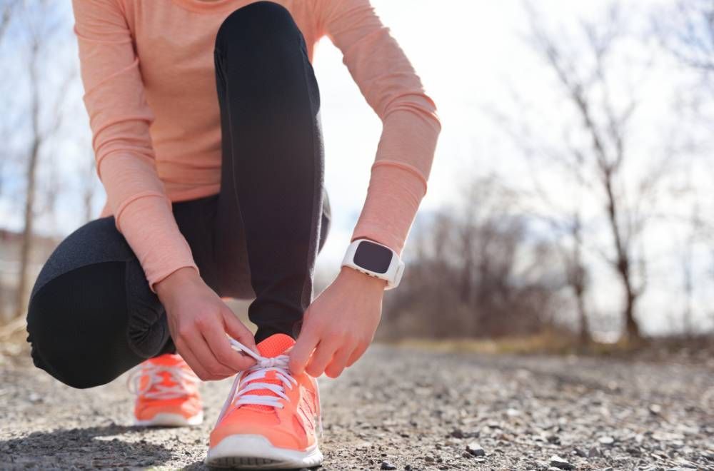 Header image of a beginner runner tying up her shoes to get ready for a run