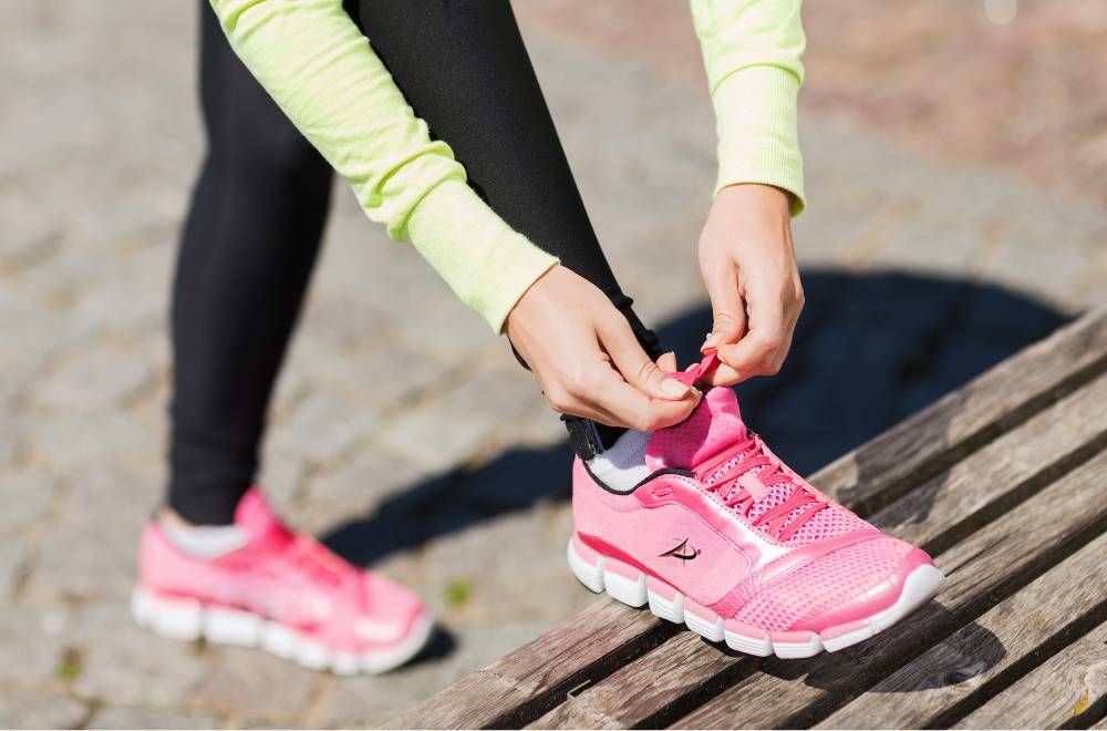 Beginner runner wearing running gear and tying up running shoes