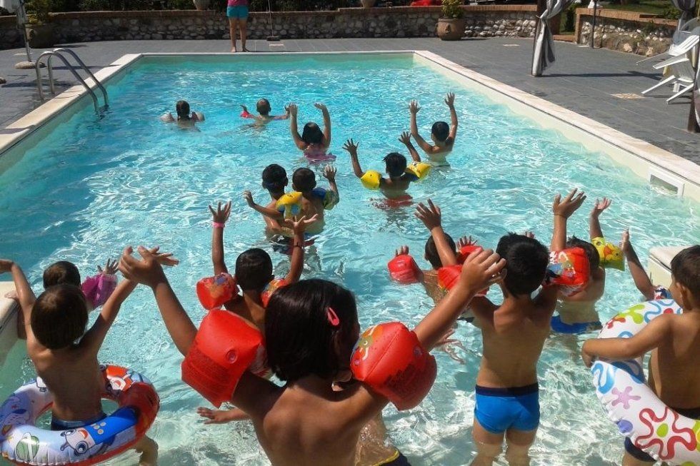 dei bambini con dei braccioli in una piscina