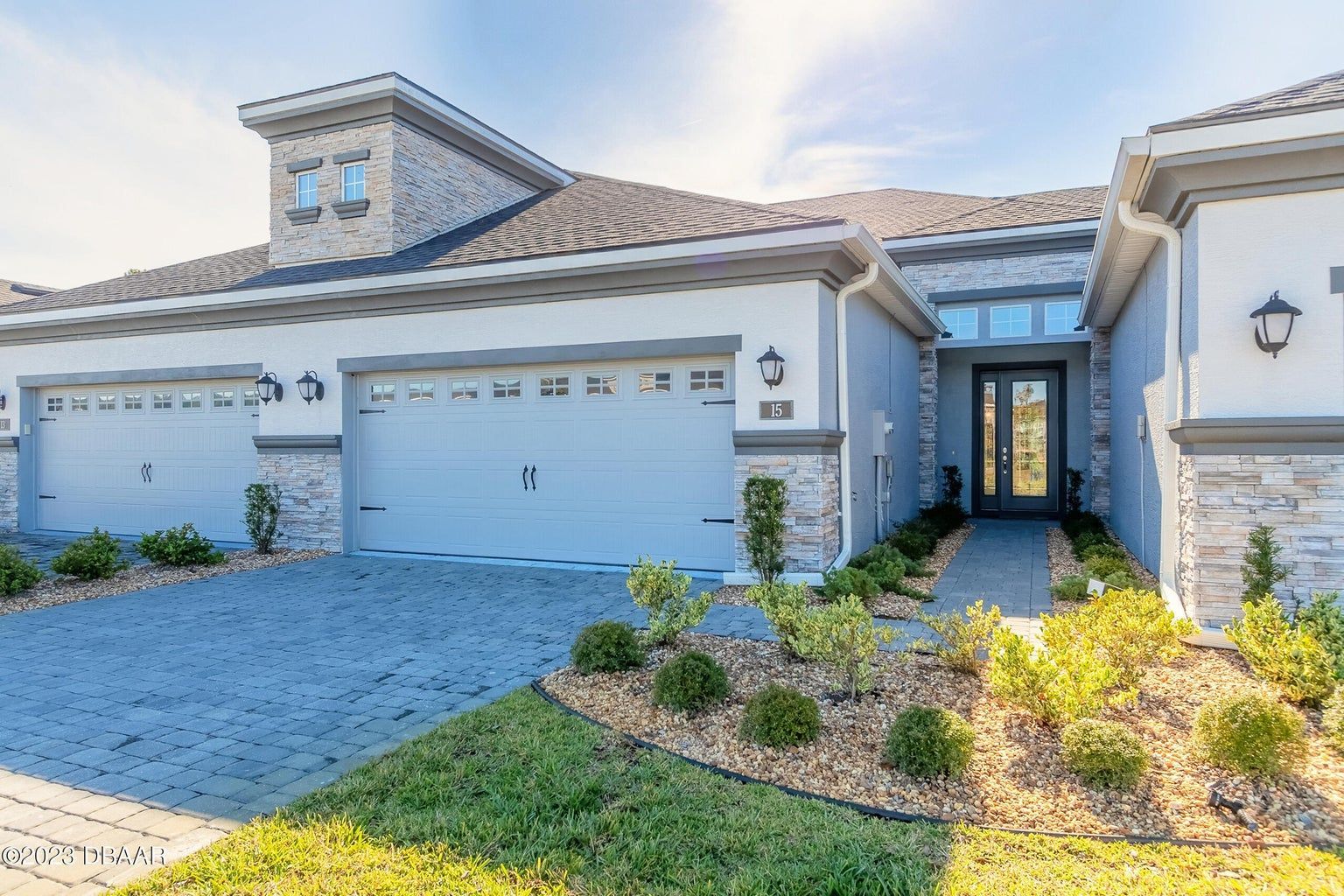 a large white house with two garage doors and a driveway