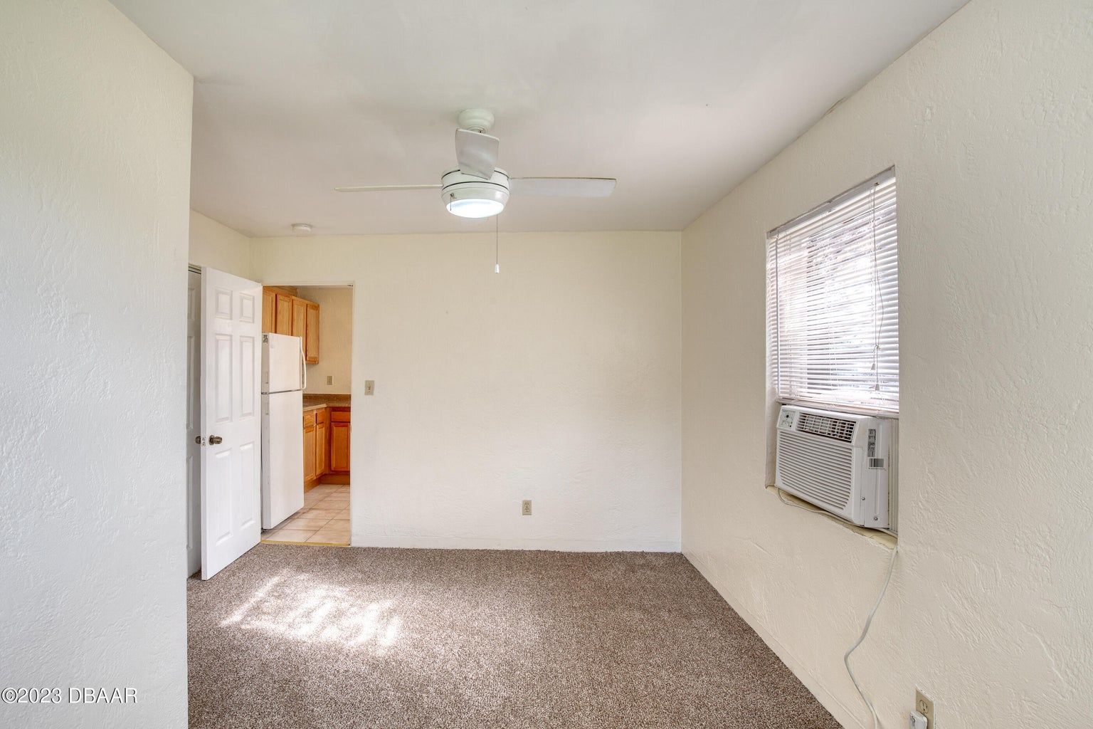an empty room with a ceiling fan and a window
