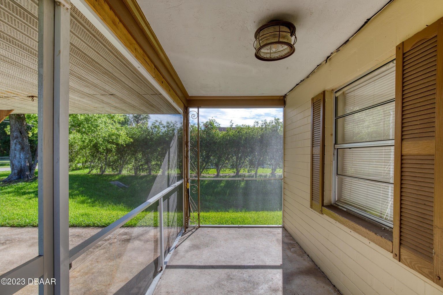 a screened in porch with a clock on the ceiling
