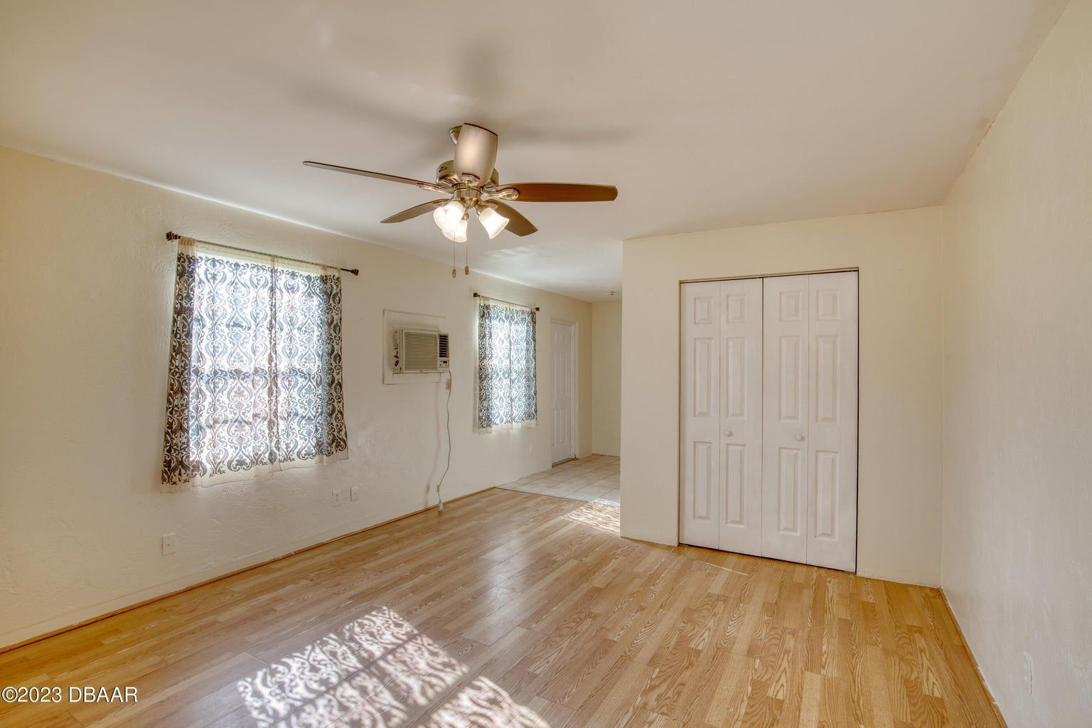 an empty room with hardwood floors and a ceiling fan