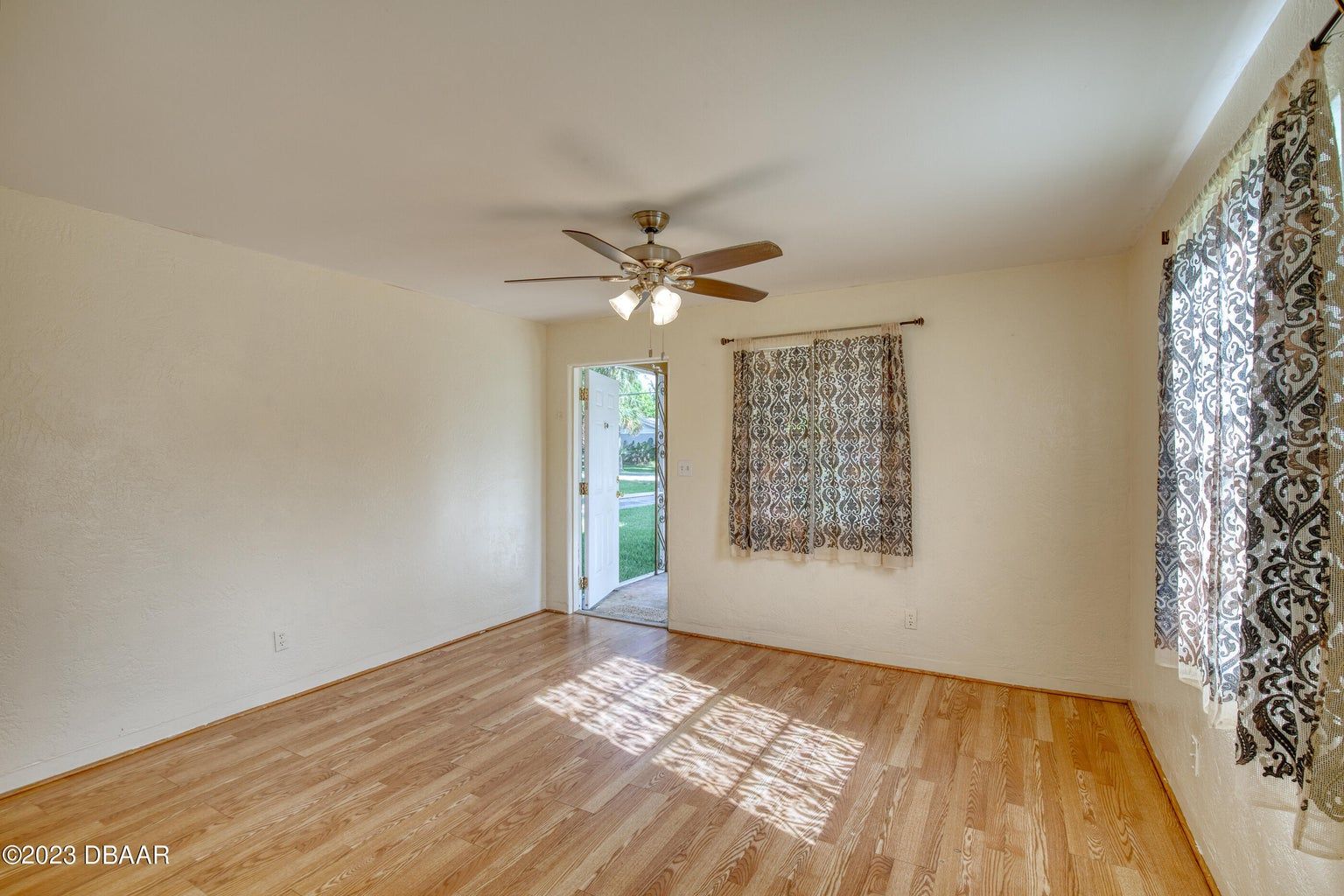an empty room with hardwood floors and a ceiling fan