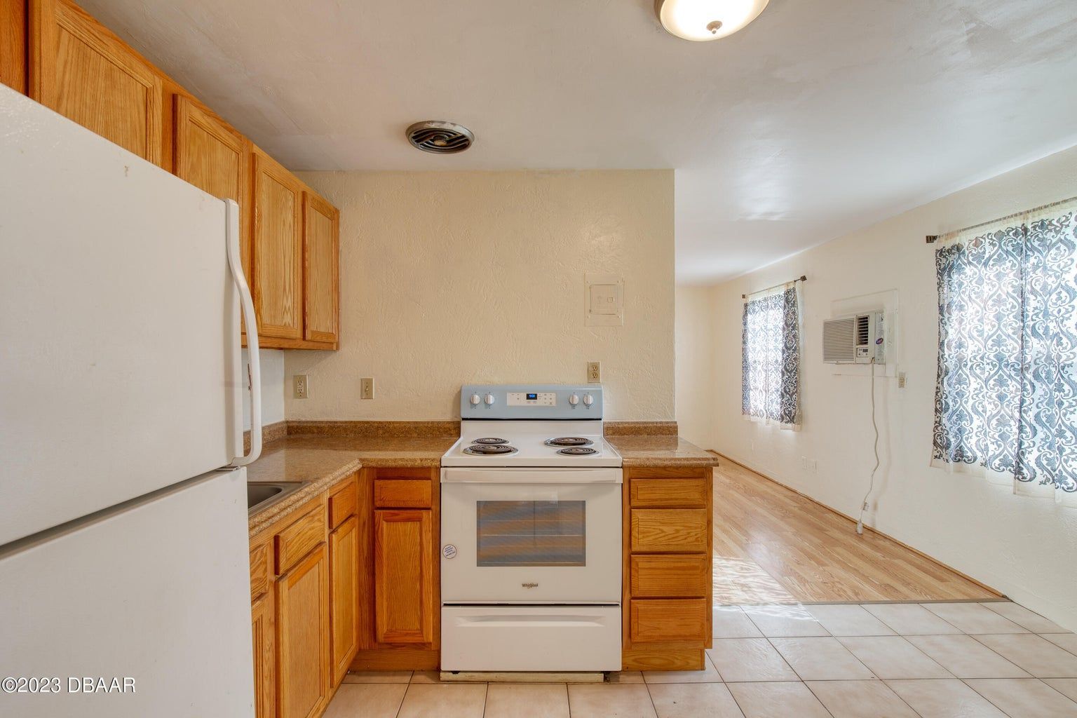 an empty kitchen with a stove and a refrigerator