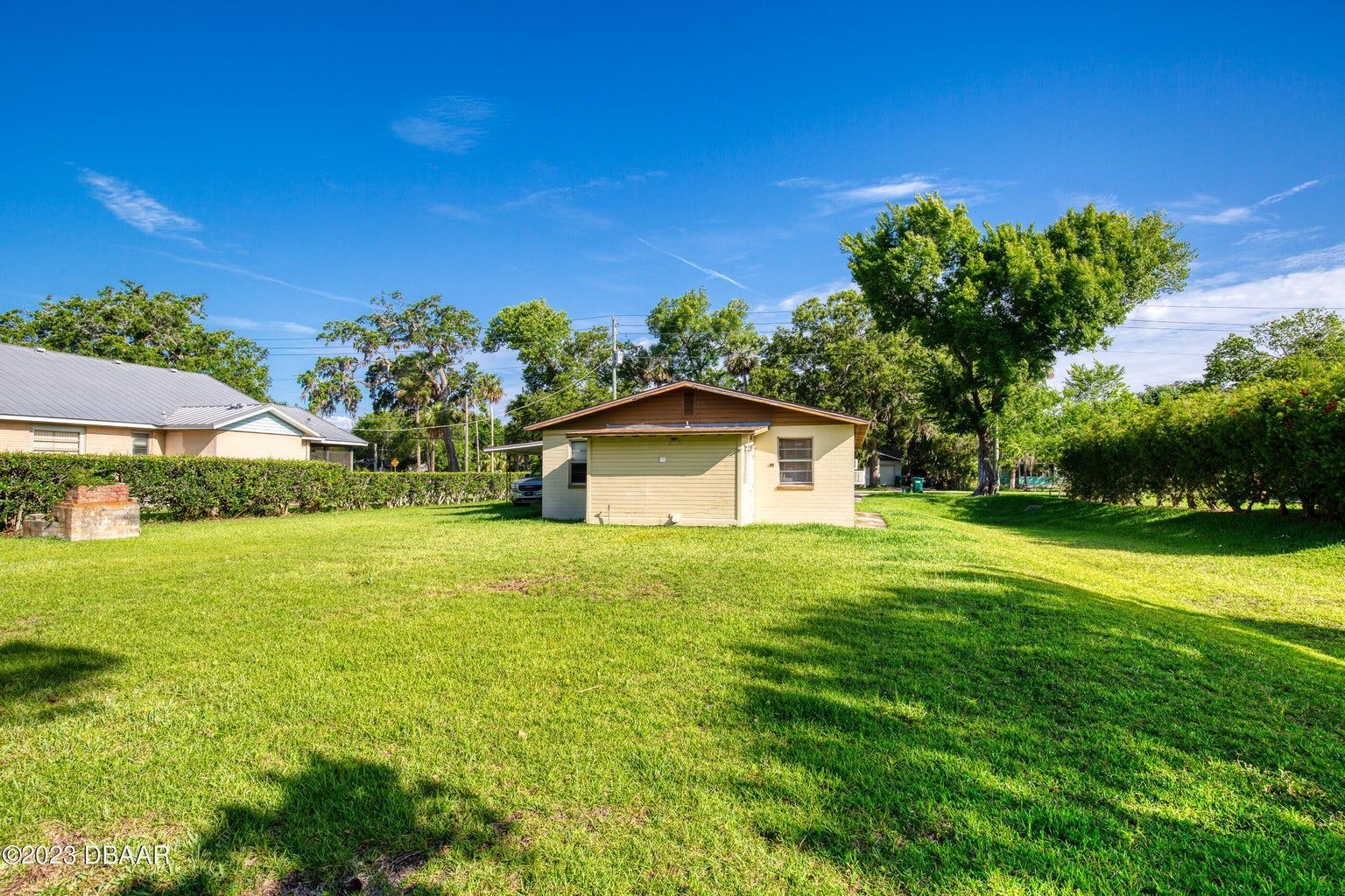 a small house sits in the middle of a lush green field