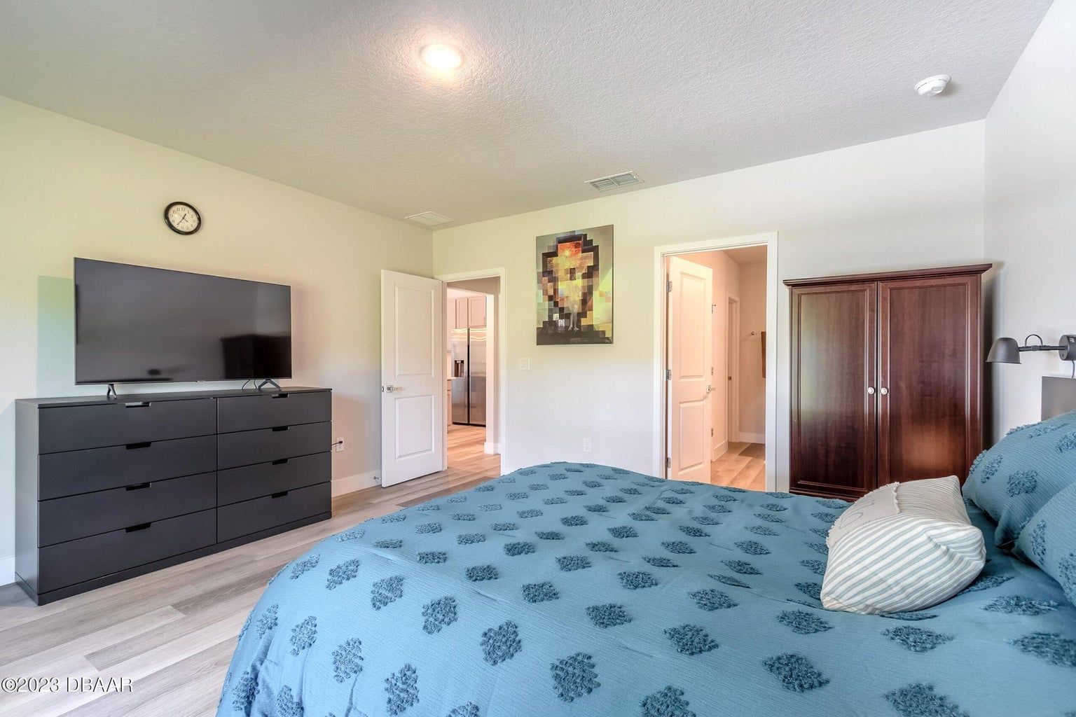a bedroom with a large bed and a flat screen tv