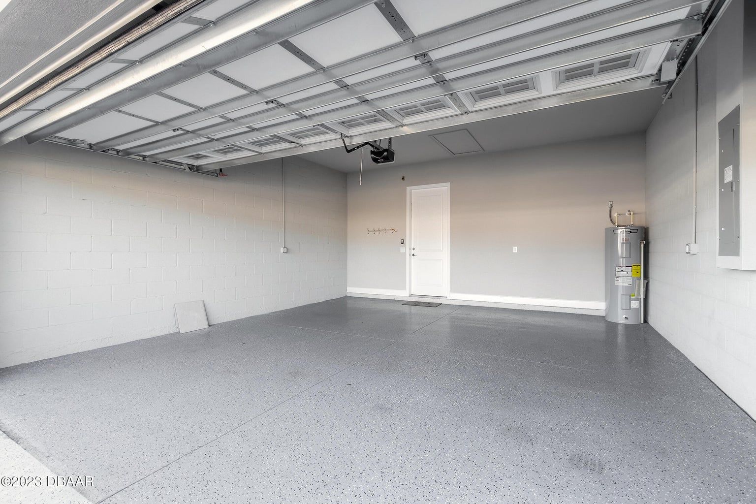 an empty garage with a gray floor and a white door