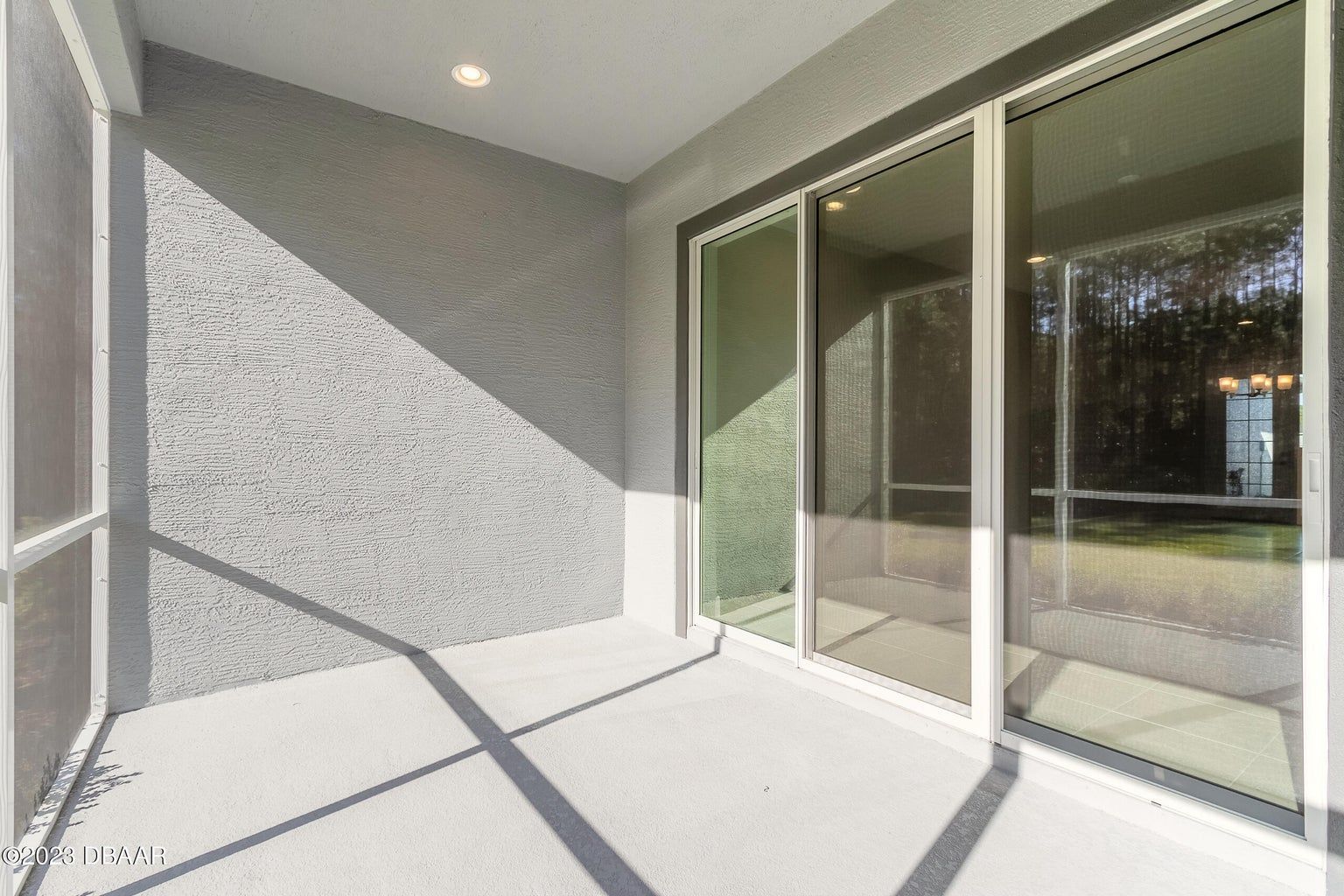 an empty room with a lot of windows and a gray wall