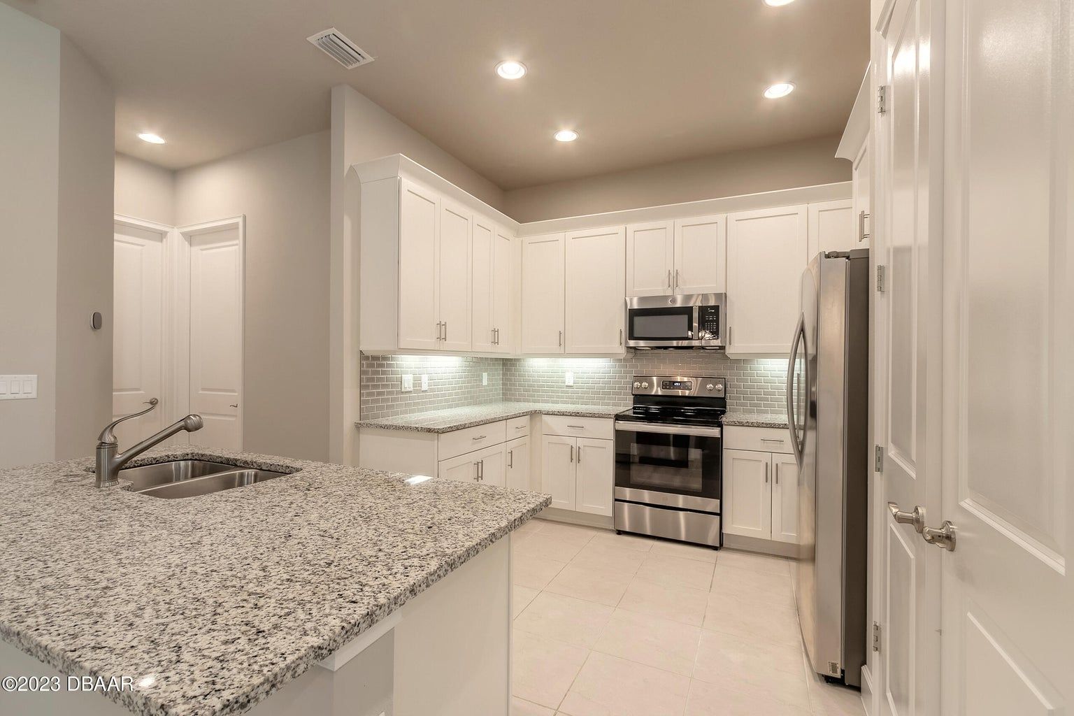 a kitchen with granite counter tops and stainless steel appliances