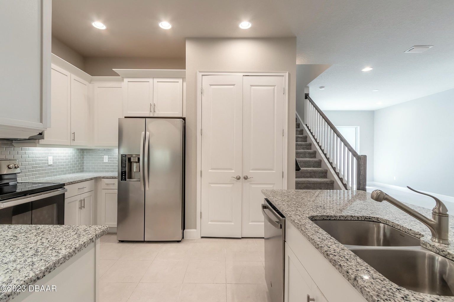 a kitchen with a stainless steel fridge