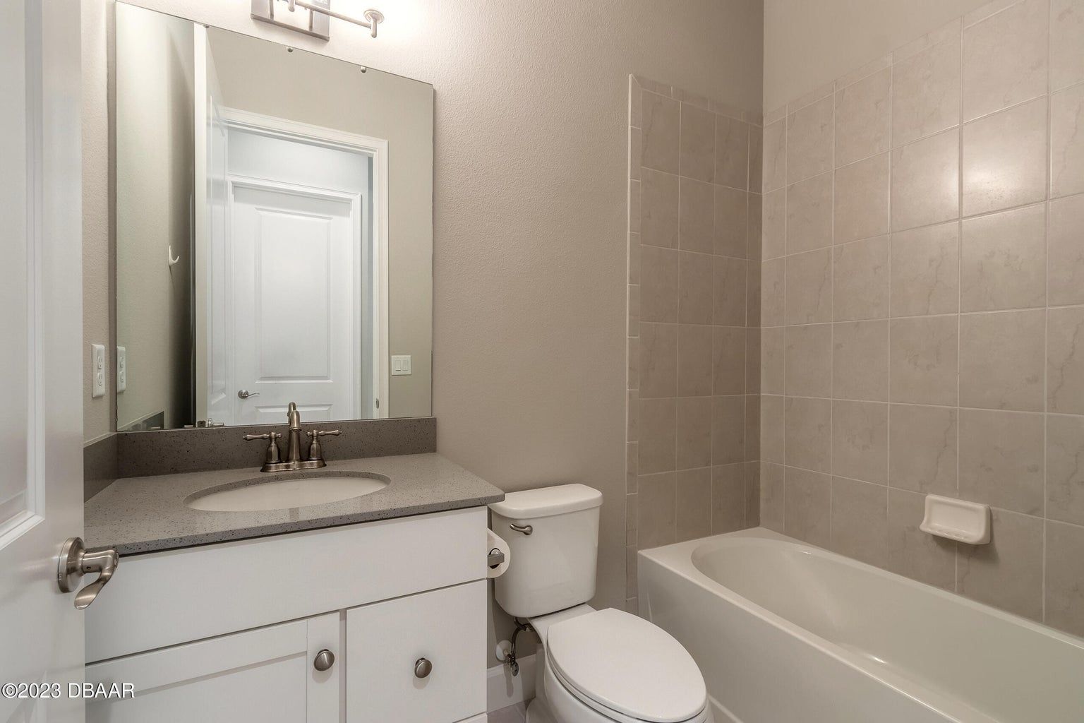 a bathroom with beige tiles lining the tub