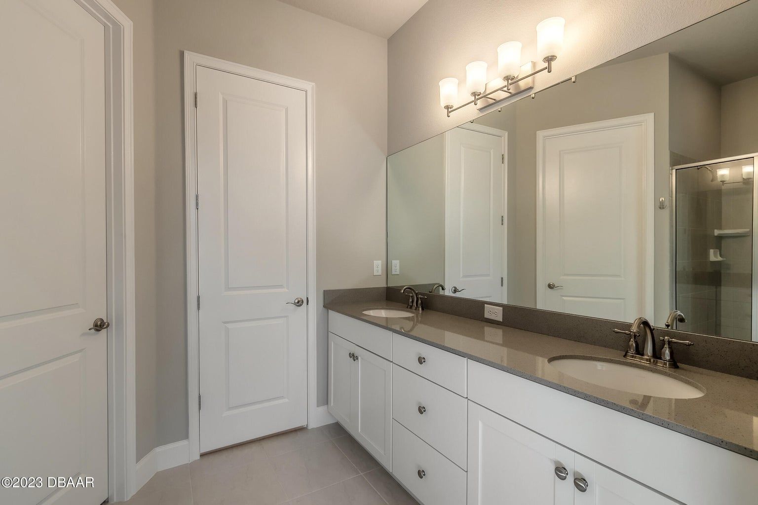 a bathroom with two sinks and a large mirror