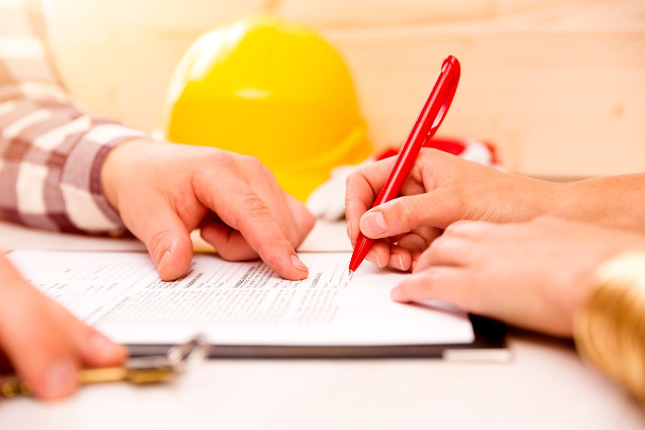 Signing Construction Documents with a yellow hardhat sitting on the table