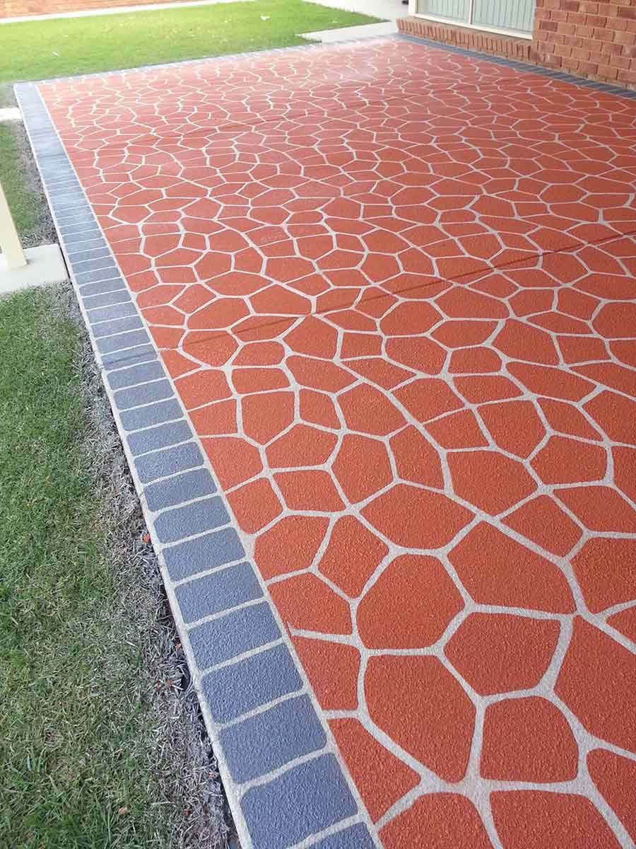 A Red And Blue Concrete Walkway With A Brick Wall In The Background — Custom Concrete Finishes In Thurgoona, NSW