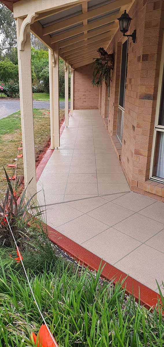 A Brick House With A Porch And A Lawn Mower In Front Of It — Custom Concrete Finishes In Thurgoona, NSW