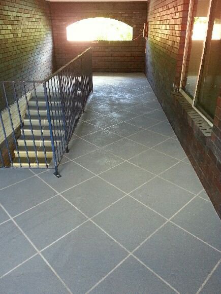 A Hallway With Stairs And A Brick Wall — Custom Concrete Finishes In Thurgoona, NSW