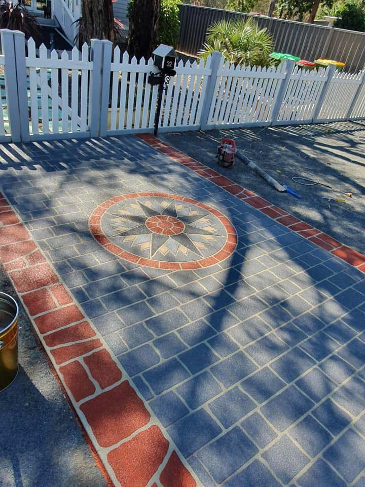 A Stenciled Patio With A White Picket Fence In The Background — Custom Concrete Finishes In Thurgoona, NSW