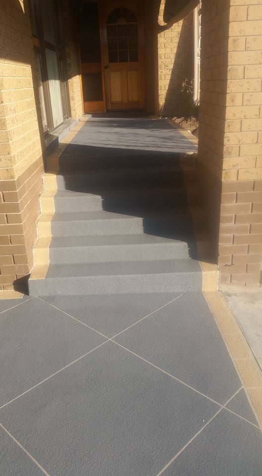 A Concrete Walkway With Stairs Leading Up To A Brick Building — Custom Concrete Finishes In Thurgoona, NSW