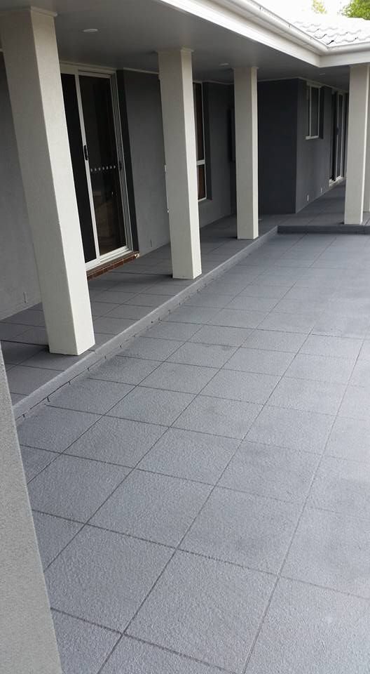 A Patio With Tiles And Columns In Front Of A House — Custom Concrete Finishes In Thurgoona, NSW