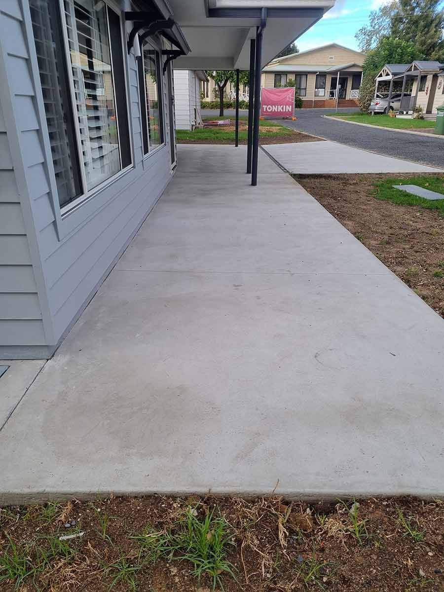 A Concrete Walkway Leading To A House In A Residential Area — Custom Concrete Finishes In Thurgoona, NSW